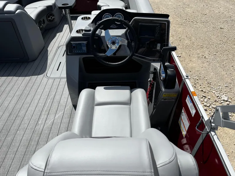 Slide: The Image of 2025 SunCatcher Fusion 322RC boat interior with steering wheel and seating. - 10