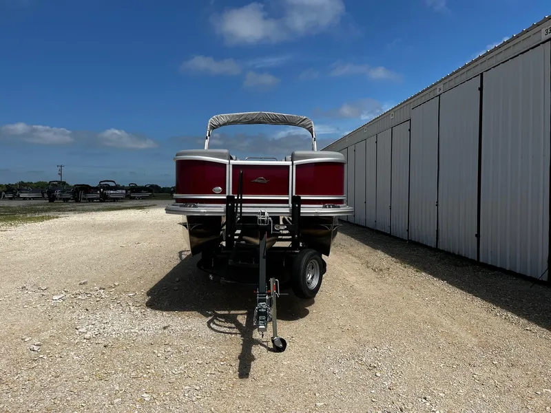Slide: The Image of 2025 SunCatcher Fusion 322RC pontoon boat on trailer, parked outdoors. - 2