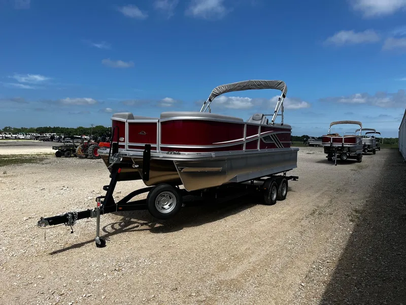 Slide: The Image of 2025 SunCatcher Fusion 322RC pontoon boat on trailer under clear blue sky. - 3
