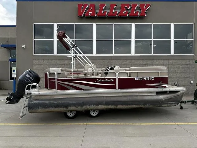 Slide: The Image of 2012 Godfrey Sweetwater pontoon boat with Yamaha motor, parked outside Vallely building. - 1