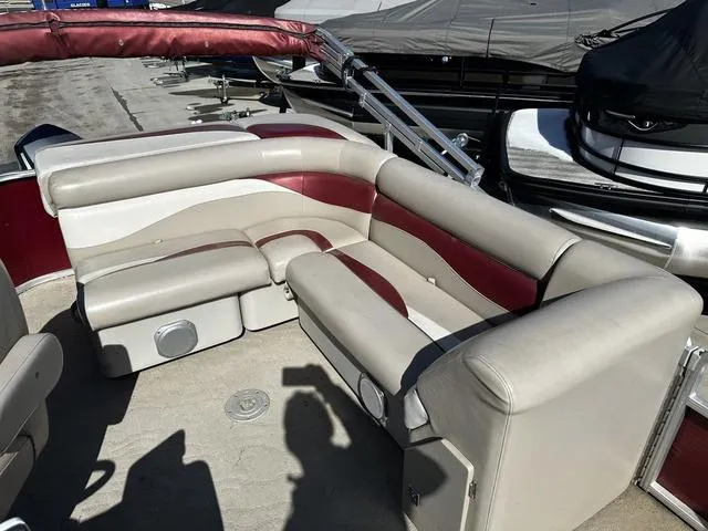 Slide: The Image of 2012 Godfrey Sweetwater boat interior with beige and maroon seating, docked at marina. - 11