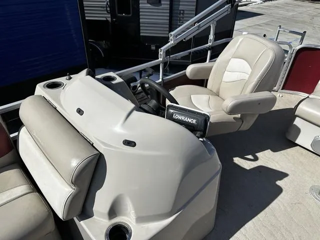 Slide: The Image of 2012 Godfrey Sweetwater boat helm with steering wheel and Lowrance device. - 12