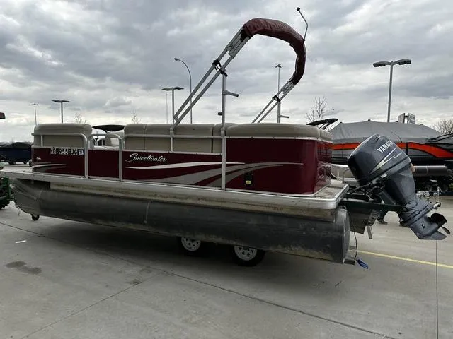 Slide: The Image of 2012 Godfrey Sweetwater pontoon boat with Yamaha outboard motor, parked outdoors under cloudy skies. - 3