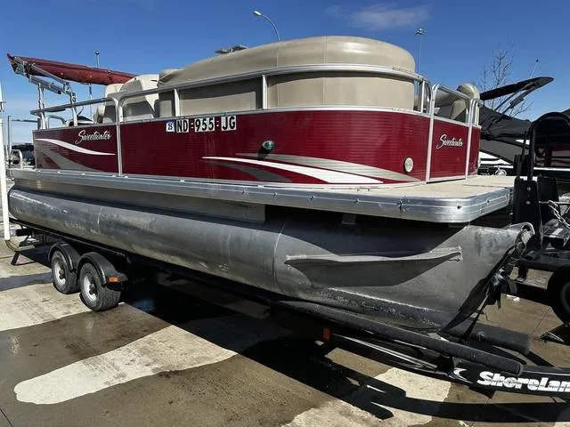 Slide: The Image of 2012 Godfrey Sweetwater pontoon boat on trailer, red and beige design, parked outdoors. - 5