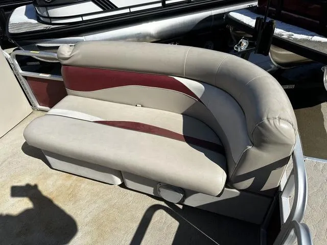Slide: The Image of 2012 Godfrey Sweetwater boat seat with beige and maroon upholstery, docked in sunlight. - 9