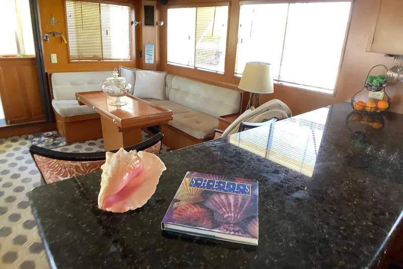 Slide: The Image of Interior of 1998 Grand Alaskan 60 Pilothouse with cozy seating and decorative elements. - 13