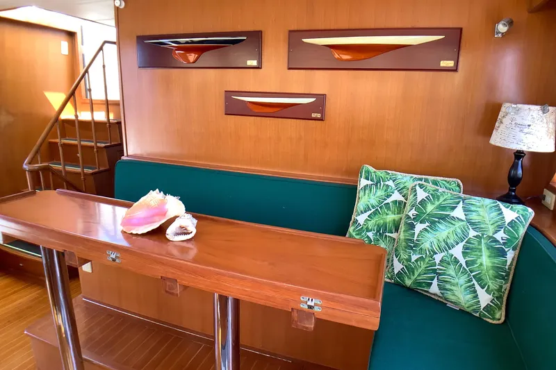 Slide: The Image of Interior of 1998 Grand Alaskan 60 Pilothouse with wooden decor and green seating. - 25