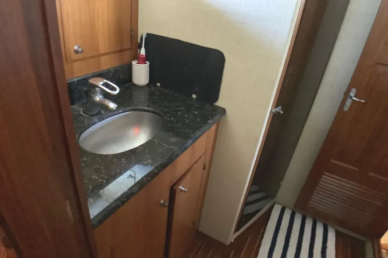 Slide: The Image of 1998 Grand Alaskan 60 Pilothouse bathroom with granite countertop and wooden cabinetry. - 37