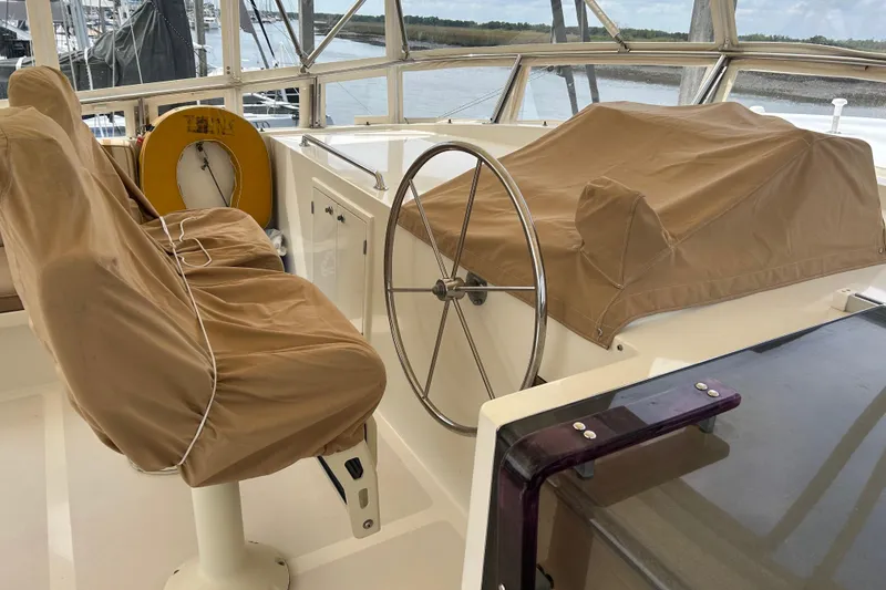 Slide: The Image of Pilothouse of 1998 Grand Alaskan 60, featuring covered seats and steering wheel. - 43