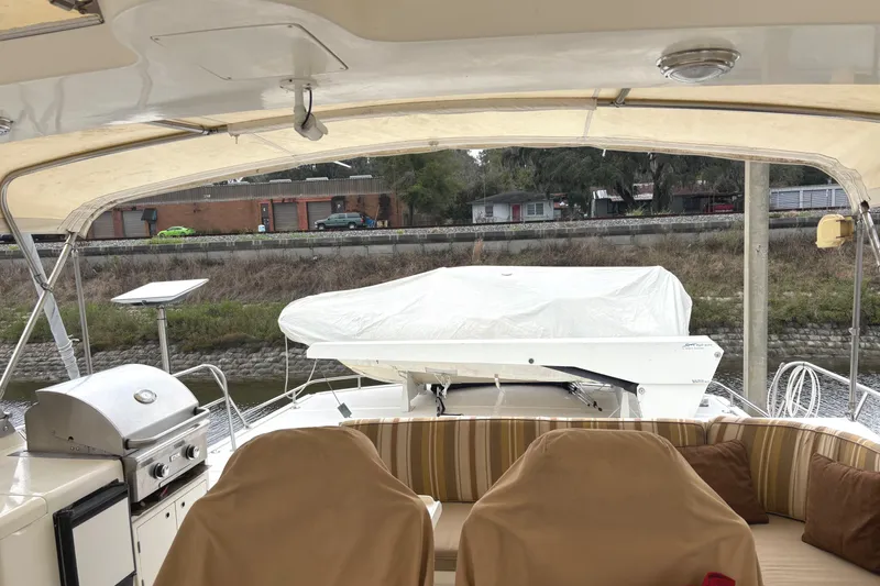 Slide: The Image of 1998 Grand Alaskan 60 Pilothouse yacht deck with seating, grill, and covered equipment. - 44