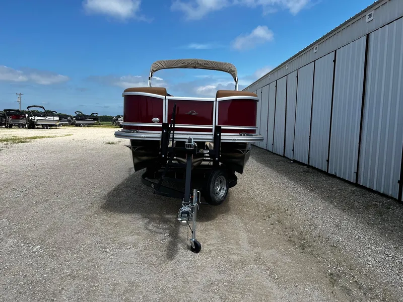 Slide: The Image of 2025 SunCatcher Fusion 324SS pontoon boat on trailer, parked outdoors. - 2