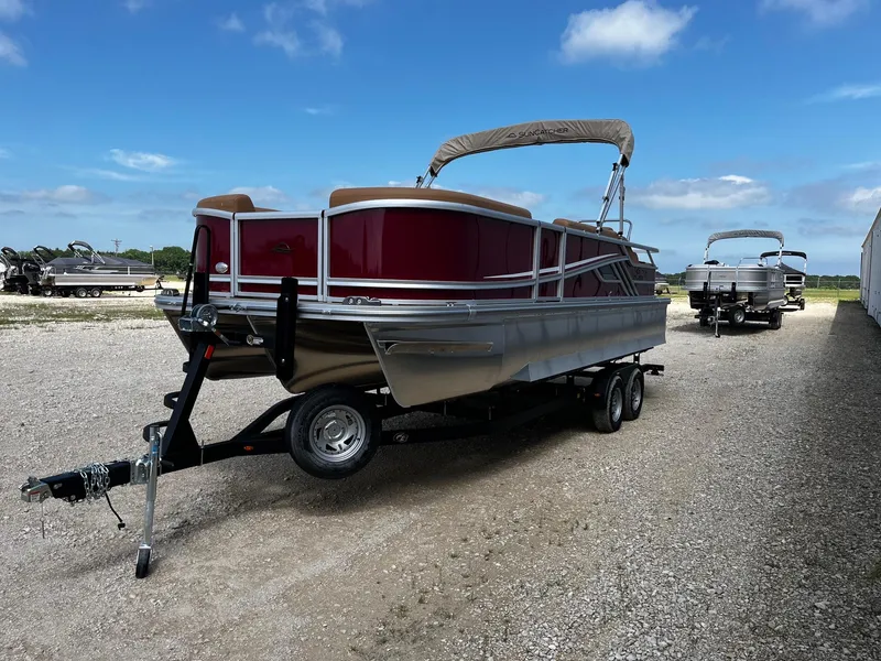 Slide: The Image of 2025 SunCatcher Fusion 324SS pontoon boat on trailer under clear blue sky. - 3