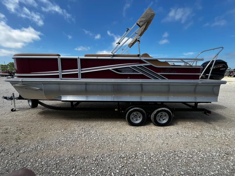 Slide: The Image of 2025 SunCatcher Fusion 324SS pontoon boat on trailer under clear blue sky. - 4
