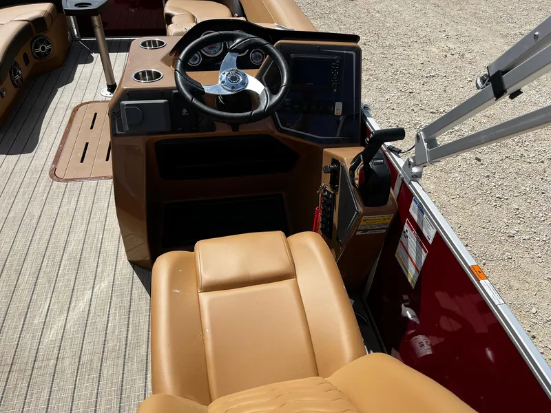 Slide: The Image of 2025 SunCatcher Fusion 324SS boat interior with tan seating and steering console. - 9