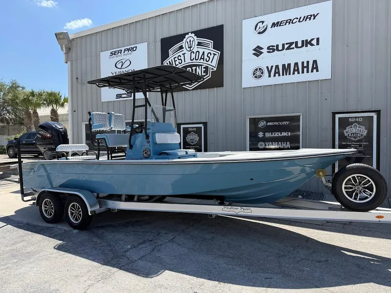 The Image of 2025 Shallow Sport 24 Modified V boat on trailer, parked outside dealership. - 1