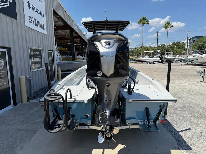 Slide: The Image of 2025 Shallow Sport 24 Modified V boat with powerful outboard motor, parked outdoors. - 10