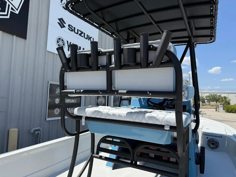 Slide: The Image of 2025 Shallow Sport 24 Modified V boat with rod holders and seating, displayed outdoors. - 15