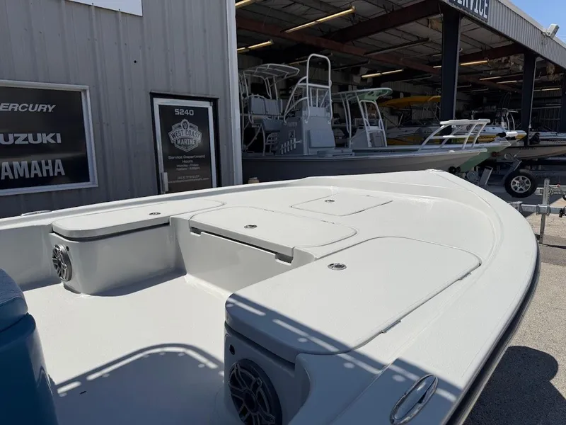 Slide: The Image of 2025 Shallow Sport 24 Modified V boat displayed at a dealership. - 7