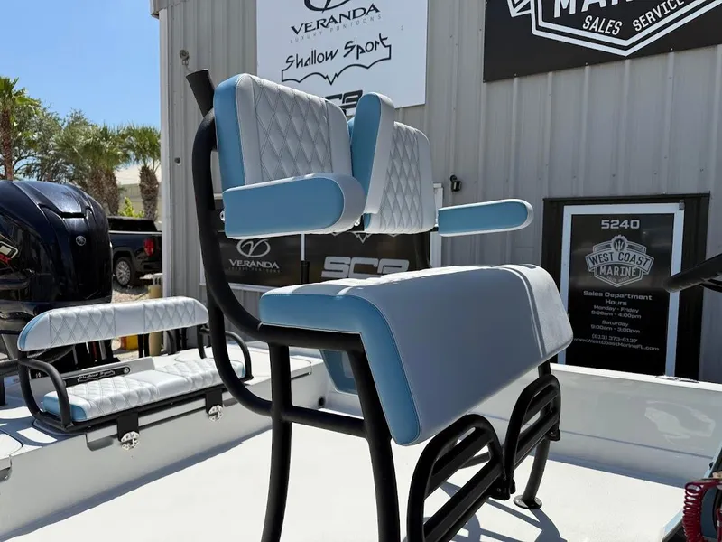 Slide: The Image of 2025 Shallow Sport 24 Modified V boat seating with blue and white upholstery, outdoor display. - 8