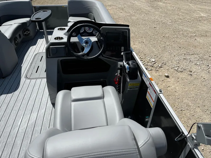 Slide: The Image of 2025 SunCatcher Fusion 324RC boat interior with steering wheel and seating. - 10