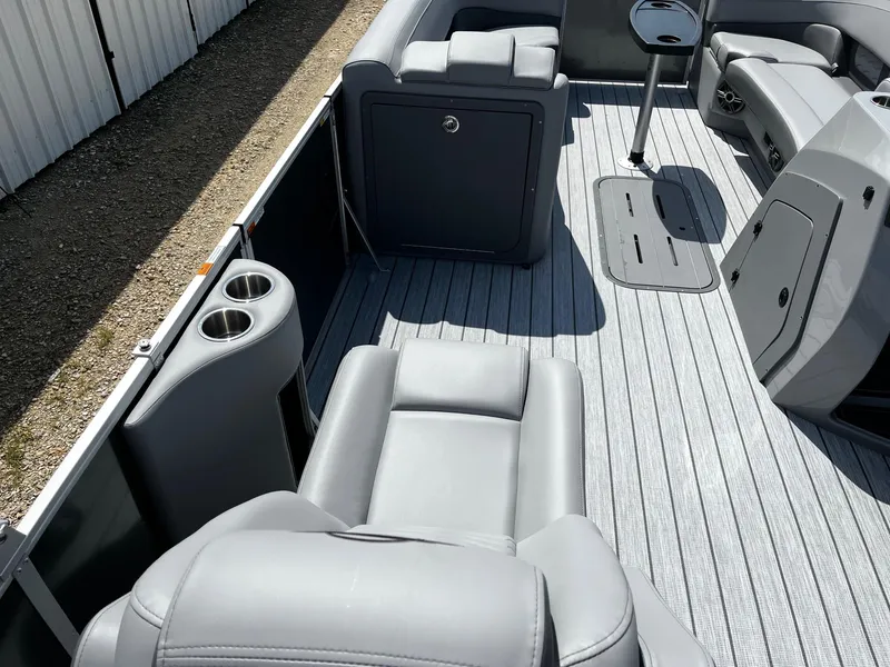 Slide: The Image of 2025 SunCatcher Fusion 324RC boat interior with gray seating and cup holders. - 11