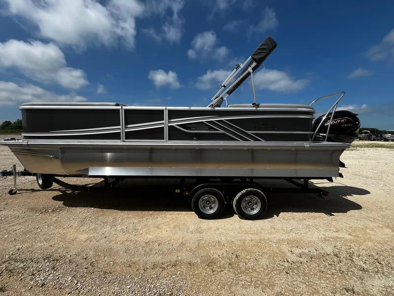 Slide: The Image of 2025 SunCatcher Fusion 324RC pontoon boat on trailer under blue sky. - 4