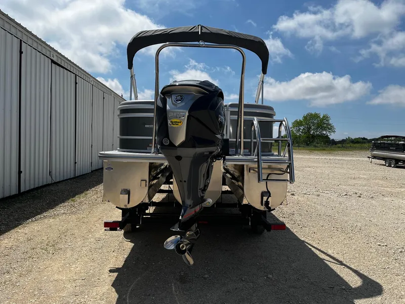 Slide: The Image of 2025 SunCatcher Fusion 324RC pontoon boat with outboard motor, parked outdoors. - 6