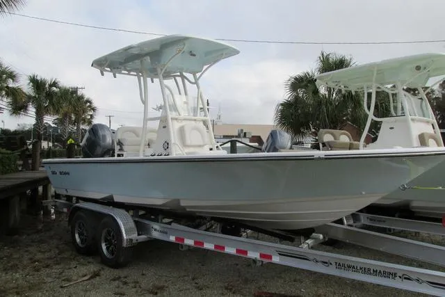 Slide: The Image of 2023 Sea Born FX22 boat on trailer, parked outdoors with palm trees in background. - 1