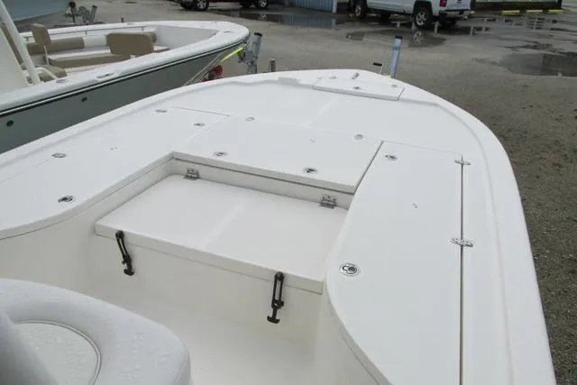 Slide: The Image of 2023 Sea Born FX22 boat deck with storage compartments, parked outdoors. - 22