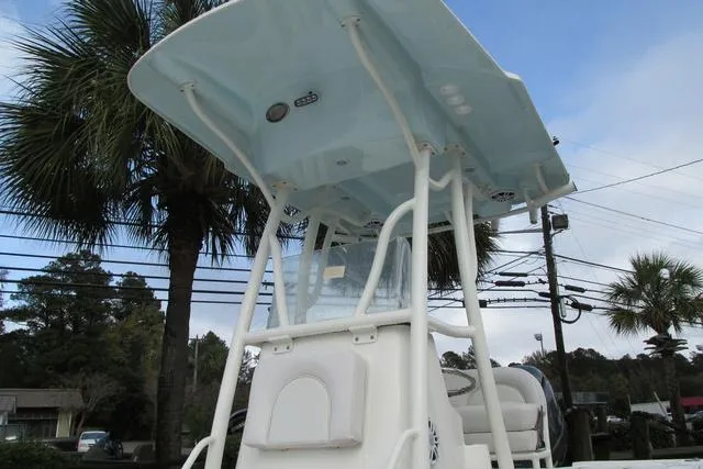 Slide: The Image of 2023 Sea Born FX22 boat with T-top, parked near palm trees and power lines. - 4
