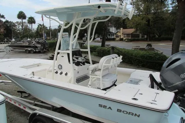 Slide: The Image of 2023 Sea Born FX22 boat on trailer, featuring center console and T-top, parked outdoors. - 6