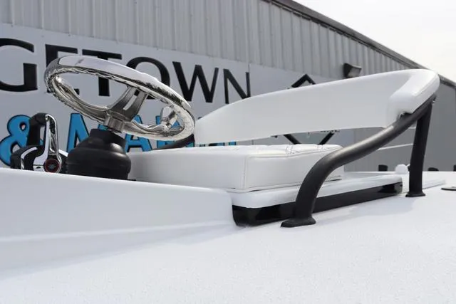 Slide: The Image of 2025 Yellowfin 26 Hybrid boat steering console with chrome wheel and white seating. - 25
