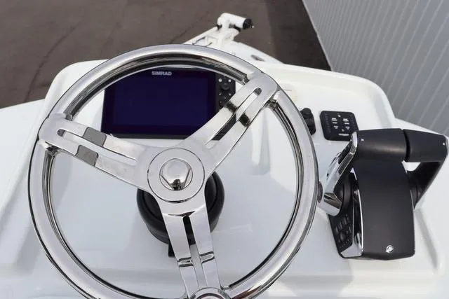Slide: The Image of Steering wheel and controls of 2025 Yellowfin 26 Hybrid boat. - 26