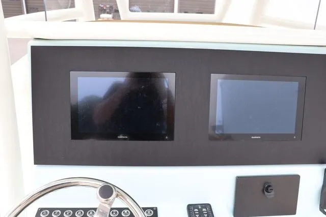 Slide: The Image of 2023 Sea Born LX26 dashboard with dual Garmin screens and steering wheel. - 16