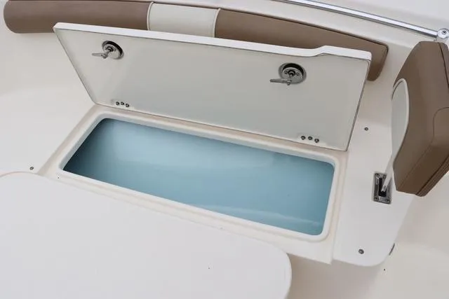 Slide: The Image of 2023 Sea Born LX26 boat storage compartment with open lid, featuring cushioned seating. - 19