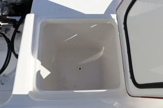 Slide: The Image of 2023 Sea Pro 219 Deep V Series boat storage compartment, open lid, white interior. - 22