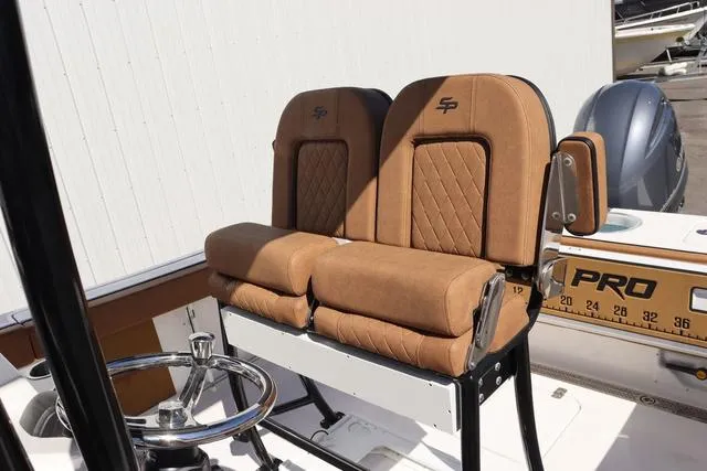 Slide: The Image of 2023 Sea Pro 219 Deep V Series boat seats with tan upholstery and steering wheel. - 7