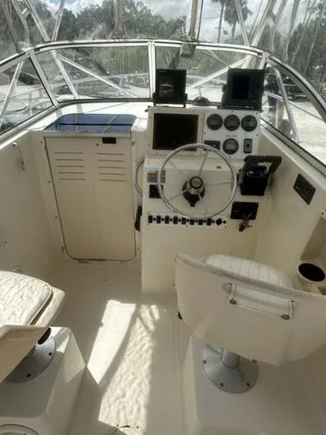Slide: The Image of 1997 Sea Pro 255 WA boat cockpit with steering wheel and control panel. - 12