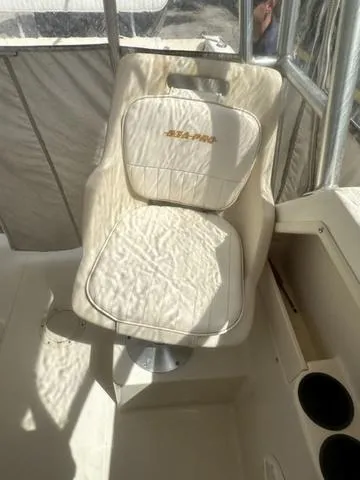 Slide: The Image of 1997 Sea Pro 255 WA boat seat with embroidered logo, featuring white upholstery and cup holders. - 13