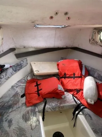 Slide: The Image of Interior of a 1997 Sea Pro 255 WA boat with life jackets and seating area. - 19