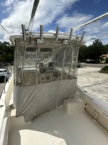 Slide: The Image of 1997 Sea Pro 255 WA boat with covered cockpit, docked under a partly cloudy sky. - 5