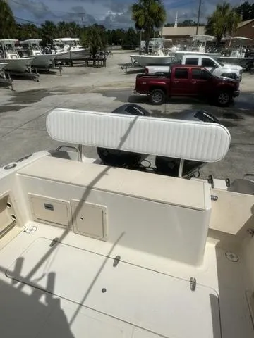 Slide: The Image of 1997 Sea Pro 255 WA boat at a marina with parked vehicles in the background. - 6