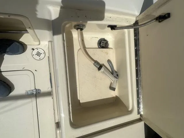 Slide: The Image of 1997 Sea Pro 255 WA boat compartment with hose and drain. - 9