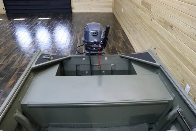 Slide: The Image of 2025 War Eagle 548LDV boat interior with motor, wooden walls, and flooring. - 4