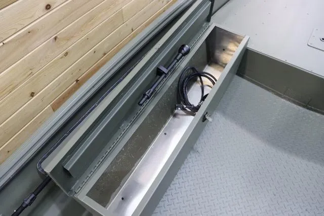 Slide: The Image of 2025 War Eagle 548LDV boat storage compartment with wooden paneling and cables. - 6