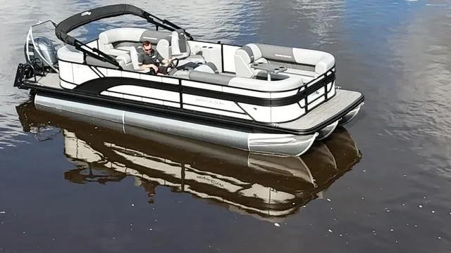 Slide: The Image of 2024 Bennington 22 SSR-SPS pontoon boat on calm water, featuring sleek design and modern seating. - 1