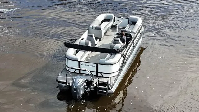 Slide: The Image of 2024 Bennington 22 SSR-SPS pontoon boat cruising on calm water. - 2