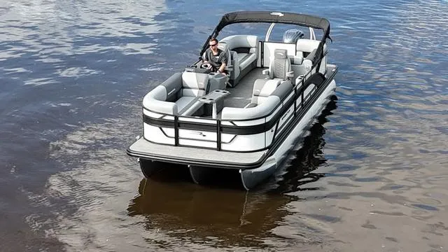 Slide: The Image of 2024 Bennington 22 SSR-SPS pontoon boat on calm water, featuring spacious seating and sleek design. - 4