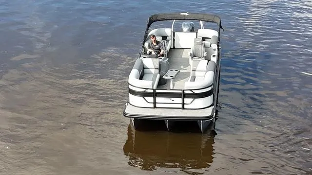 Slide: The Image of 2024 Bennington 22 SSR-SPS pontoon boat on calm water, featuring spacious seating. - 6