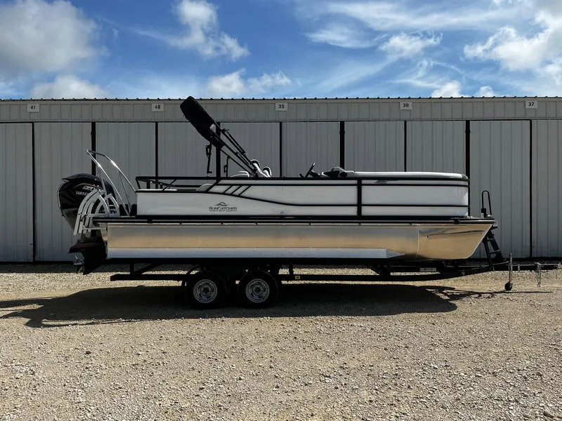 Slide: The Image of 2025 SunCatcher Select 322SS pontoon boat on trailer, parked outdoors. - 0